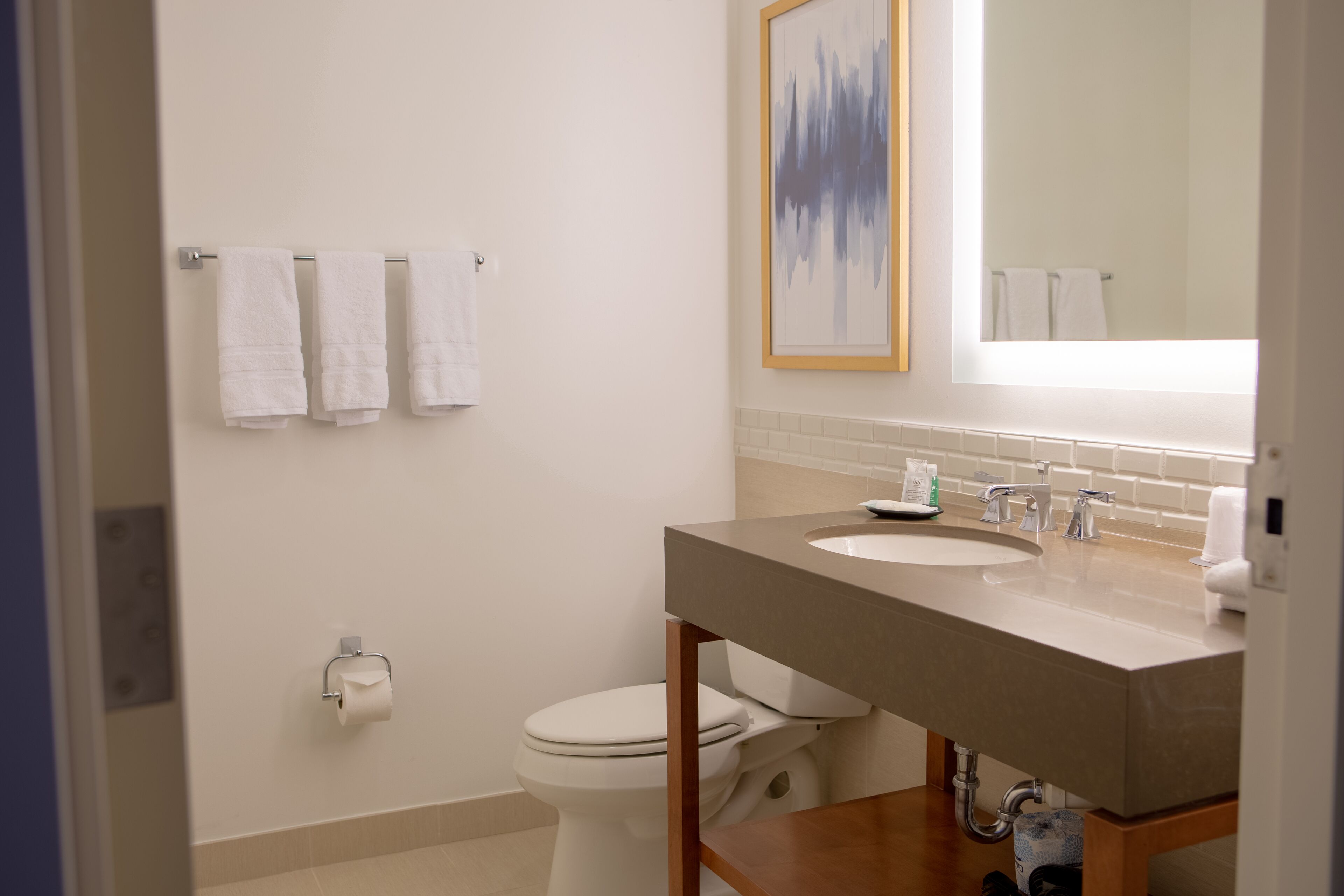A bathroom with a toilet, sink, and towel rack.