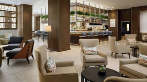 A modern hotel lobby with seating areas, a bar, and a reception desk. - The Westin Austin at The Domain (Austin)