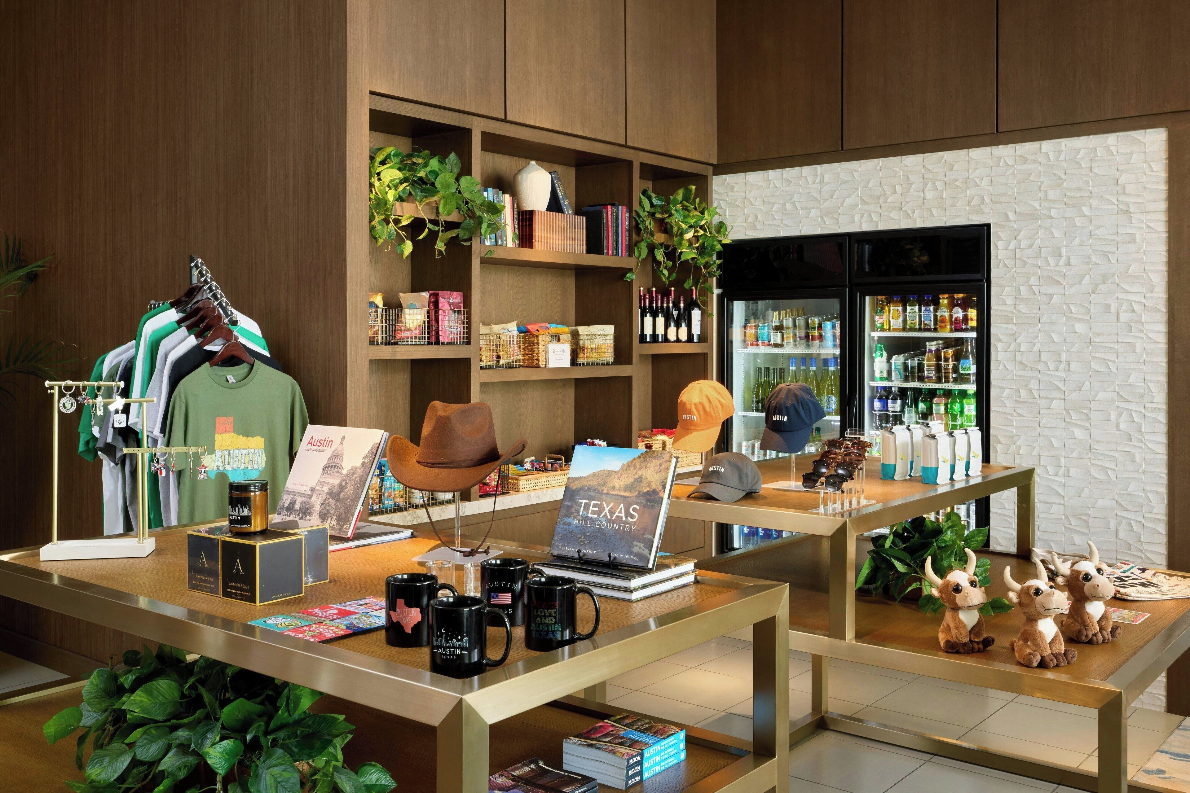 A hotel lobby with wooden shelves displaying books, hats, and a laptop with a Texas-themed book.