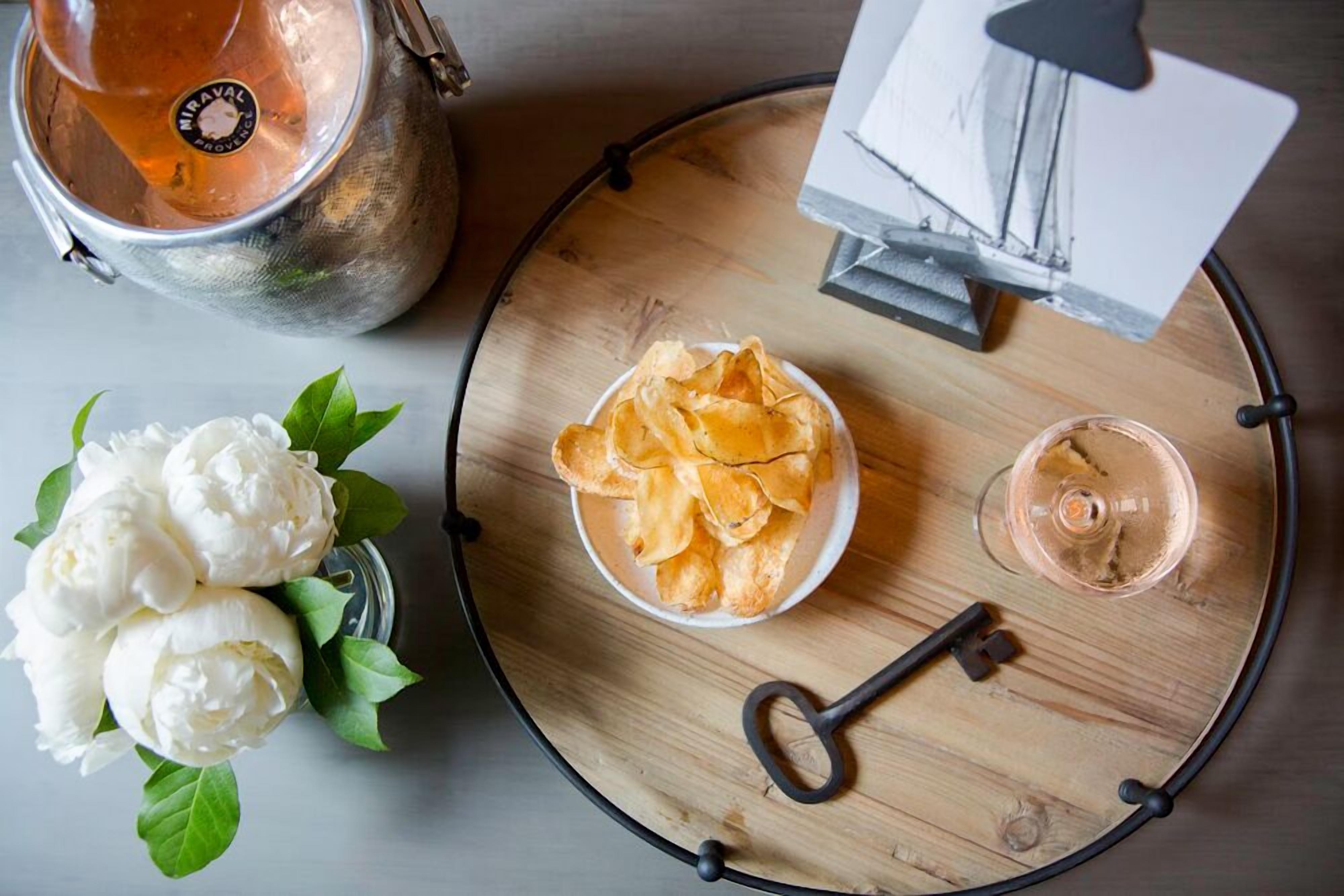 A tray with chips, a glass of wine, and a key.