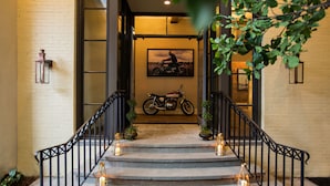 A staircase with a motorcycle parked at the top, surrounded by lanterns and potted plants.