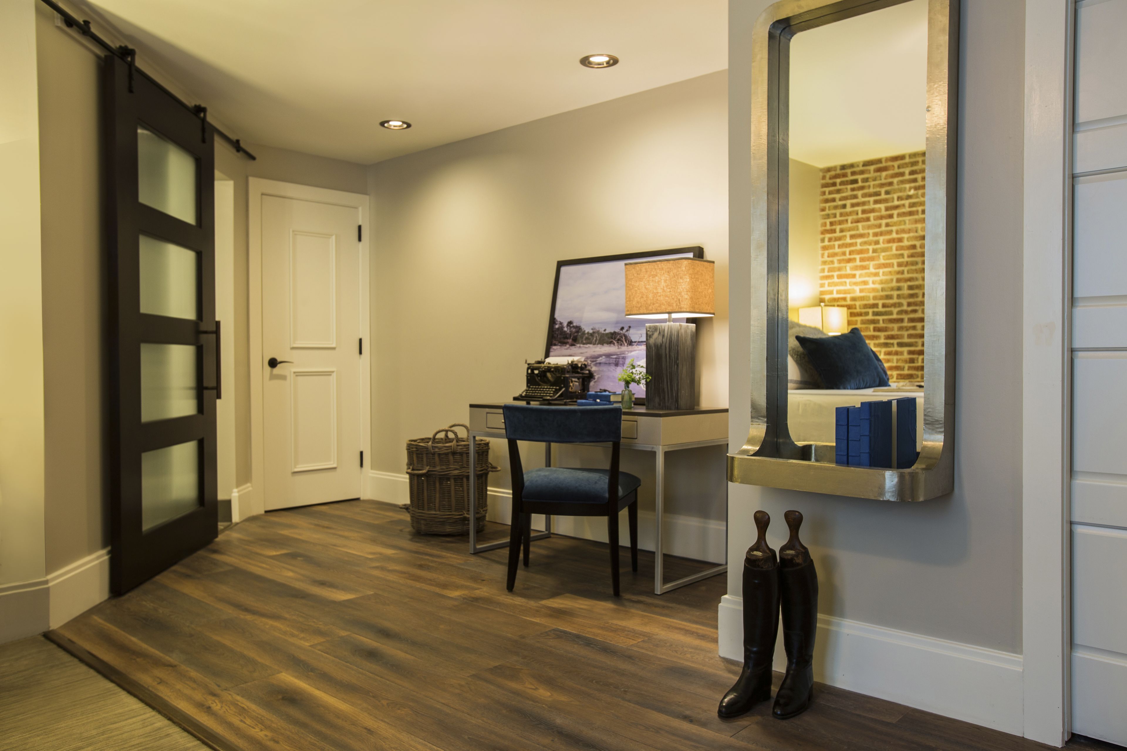 A modern room with a desk, chair, and a large mirror.