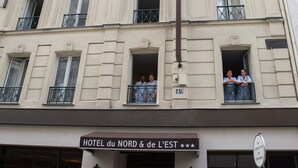 A multi-story hotel with balconies and a sign reading "HOTEL du NORD & de L'EST". - Hotel du Nord et de l'Est (Paris)