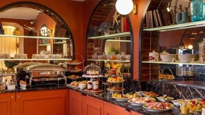 A buffet with various food items and a mirror reflecting the room. - Hotel du Nord et de l'Est (Paris)