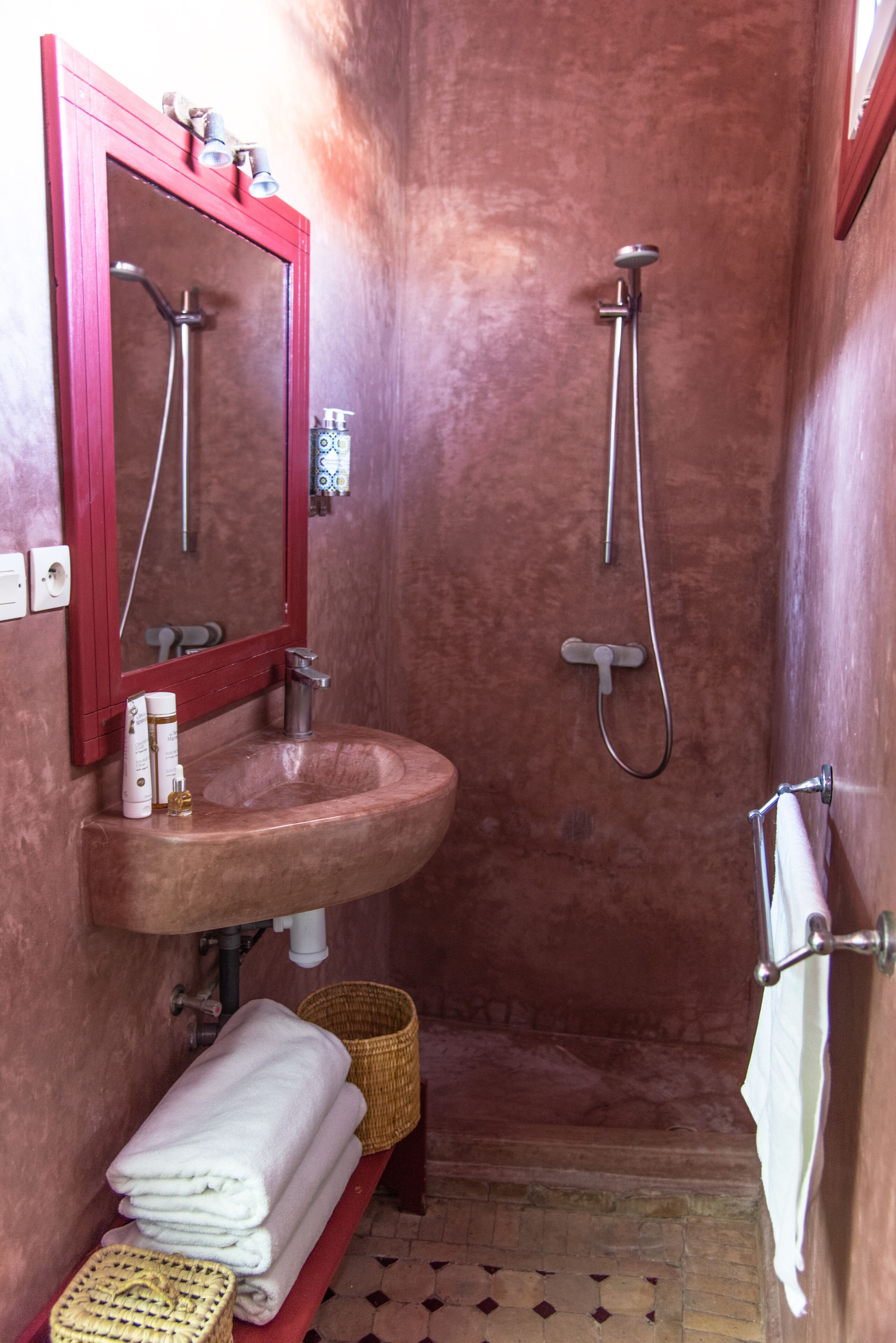 Une salle de bain équipée d’un lavabo, d’un miroir, d’une douche et d’un porte-serviettes.