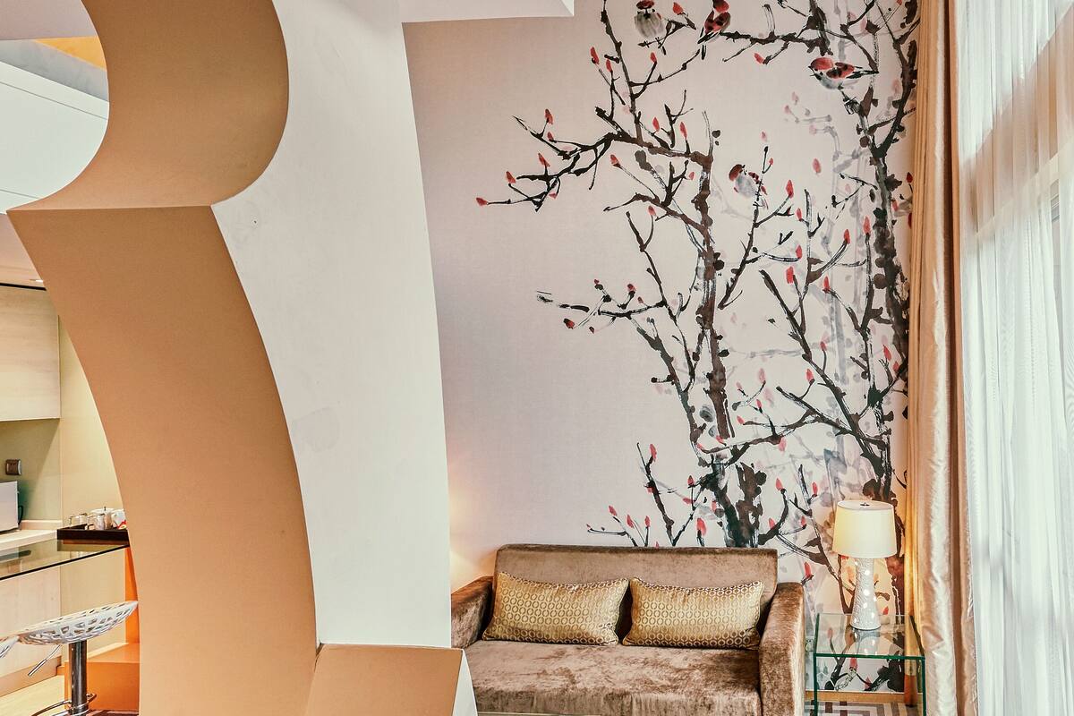 Una sala de estar moderna con un sofá, una mesa de centro y una alfombra estampada.