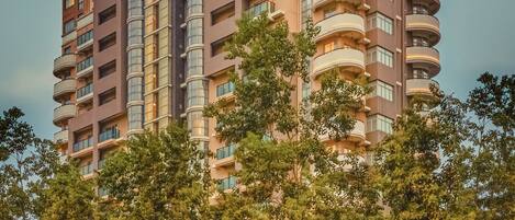 A multi-story hotel with a modern architectural design, featuring balconies and large windows.
