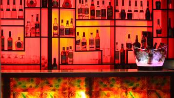 A bar area with shelves of liquor bottles and glasses.