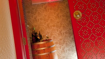 Un pasillo con un letrero de neón para el Feng Shui Bar, un barril de madera y un papel tapiz estampado.