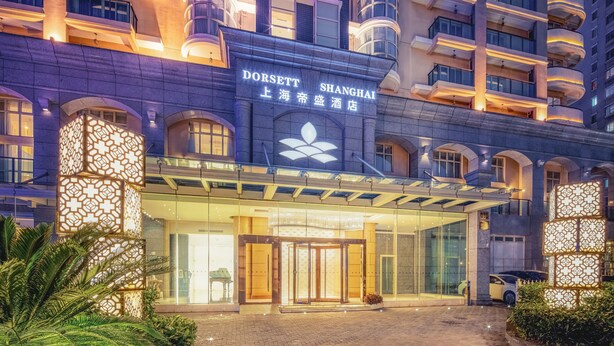 A hotel entrance with a glass facade, a prominent brand sign, and a modern architectural design. - Dorsett Shanghai (Shanghai)