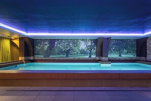 A swimming pool with a view of trees and a sunset. - Pestana Chelsea Bridge Hotel & SPA (London)