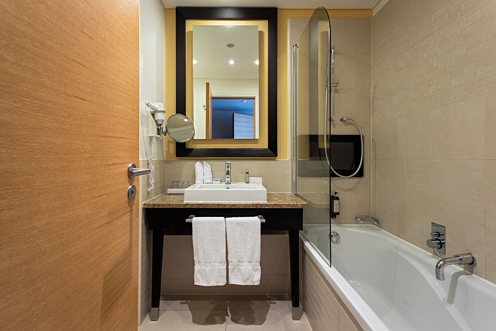 A bathroom with a bathtub, a sink, a mirror, and a shower.