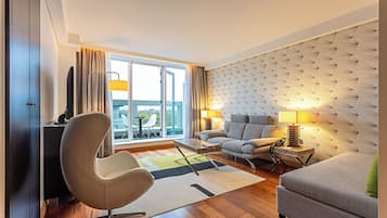 Una sala de estar moderna con un sofá, un sillón y una mesa de comedor.