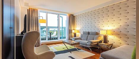 Una sala de estar moderna con un sofá, un sillón y una mesa de comedor.