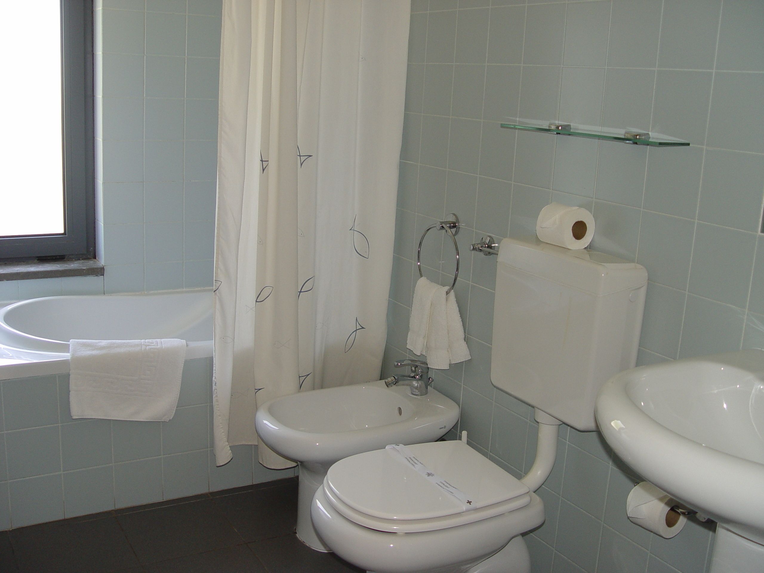 Un baño con bañera, inodoro, bidé y lavabo.