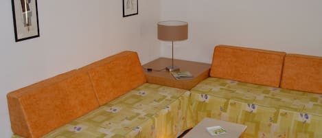 Una habitación con un sofá, una mesita y una lámpara.