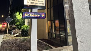 Une enseigne d’hôtel indiquant « Baymont by Wyndham » et « Ouvert sous une nouvelle direction ».