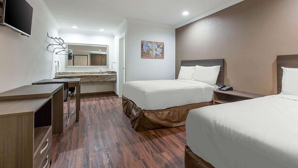 Une chambre d’hôtel comprenant un lit, une table de chevet, un bureau et un miroir.