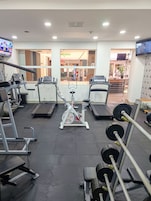 A gym with treadmills, weight machines, and a rowing machine.