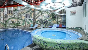 A swimming pool with mosaic tile walls and a circular hot tub area. - Suites Inn La Muralla Metepec (Toluca)