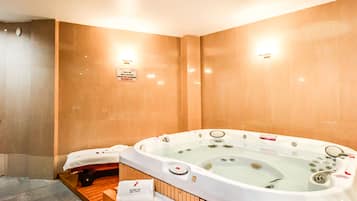 Relax in a serene spa room with a large hot tub featuring multiple jets.