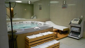 A spa room with a hot tub, a massage table, and a sauna. - Suites Inn La Muralla Metepec (Toluca)