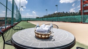 A round table with a woven basket containing towels and a water bottle. - Suites Inn La Muralla Metepec (Toluca)