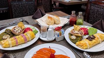 Une salle à manger de restaurant avec des tables dressées pour le service, comprenant des assiettes de nourriture et des condiments.