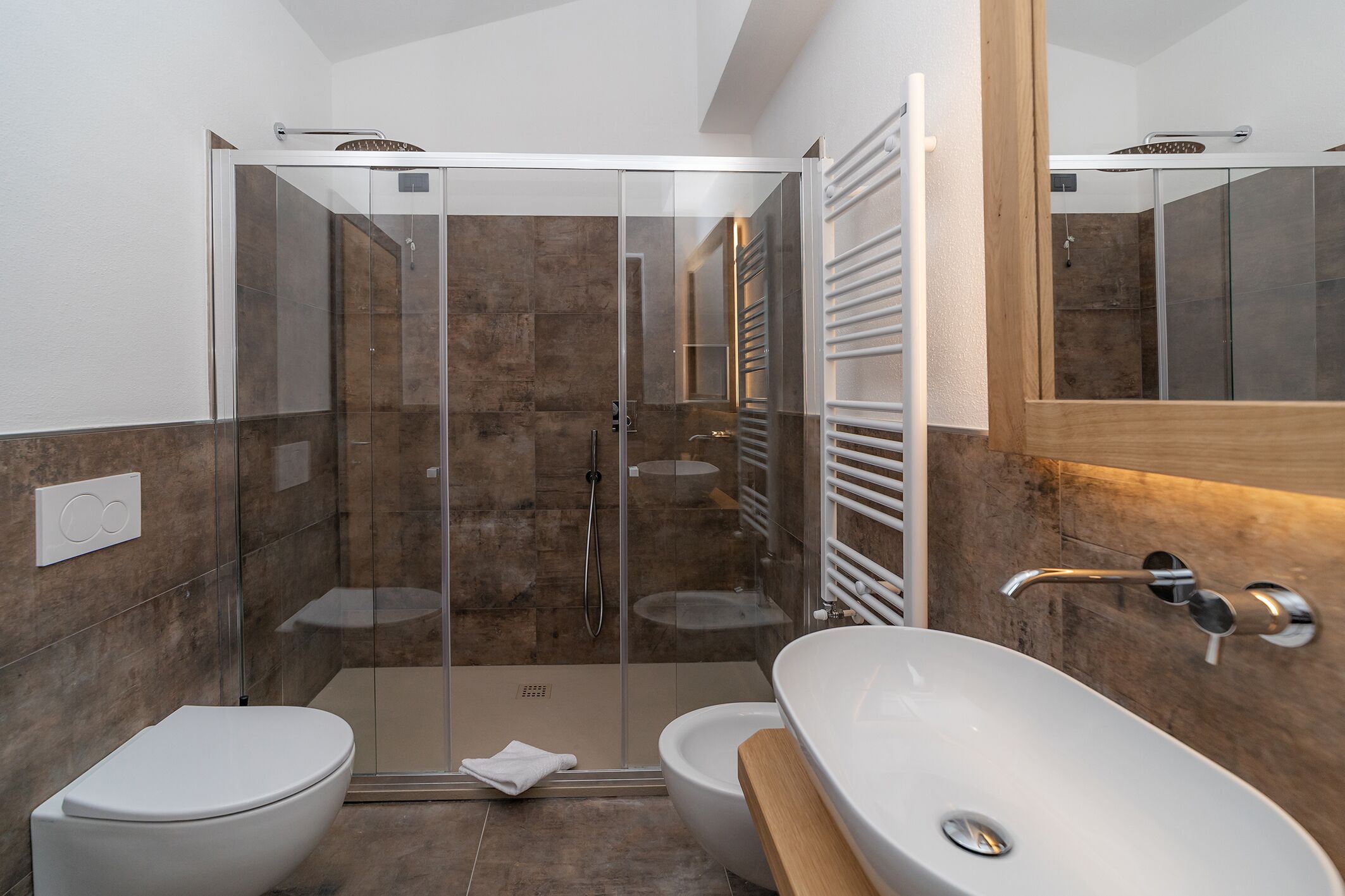 A modern bathroom with a glass-enclosed shower, a white toilet, and a freestanding bathtub.