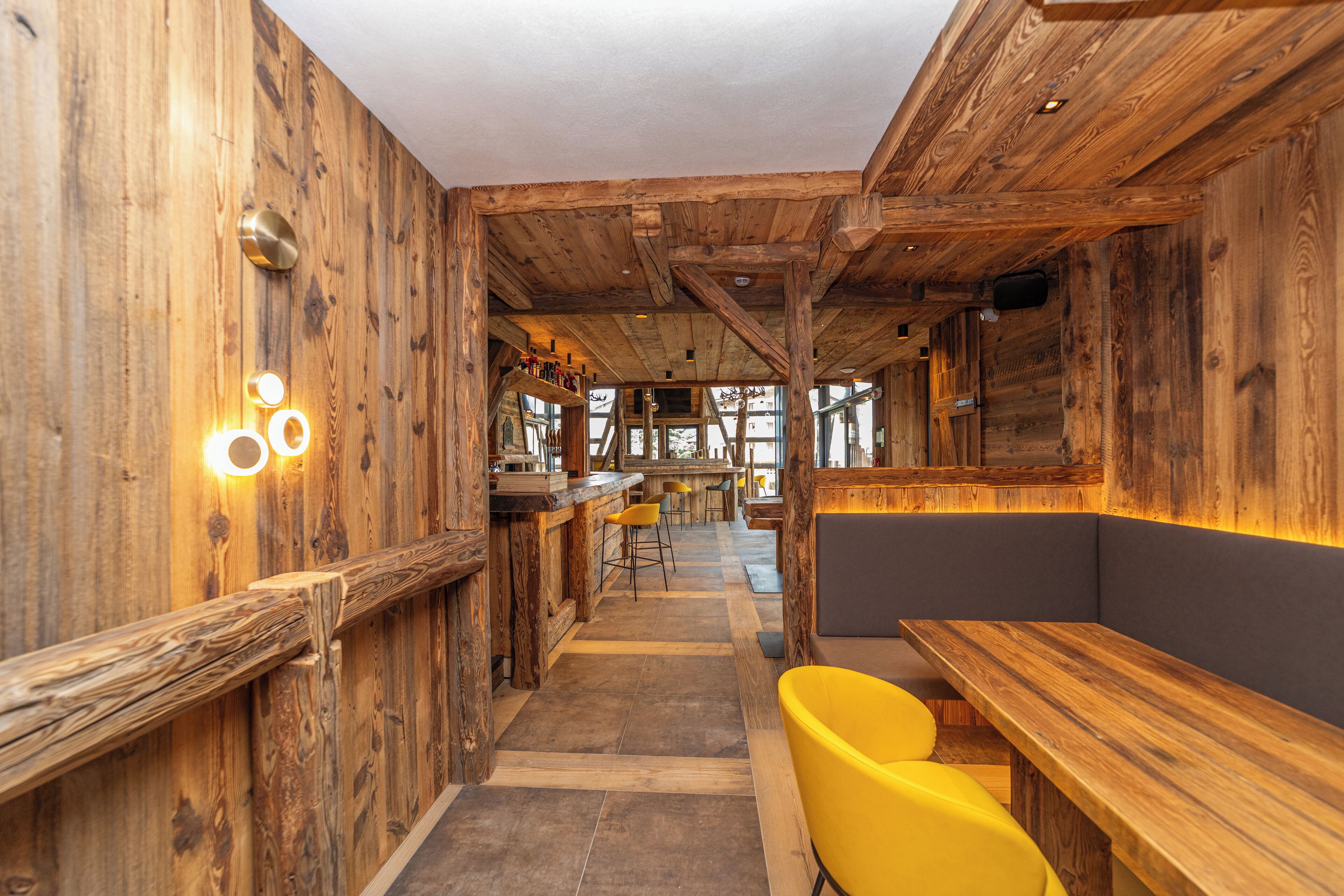 Un interior rústico con paredes de madera, una zona de bar y asientos.