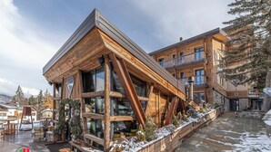 Un edificio moderno de madera con ventanas grandes y techo inclinado.