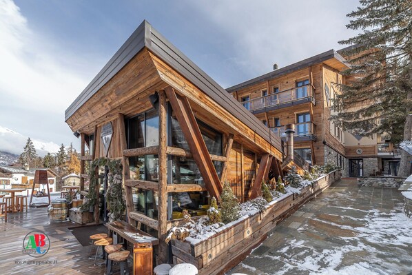 A modern wooden building with large windows and a sloped roof. - Avalanche - Alpine Boutique Hotel (Sauze d'Oulx)