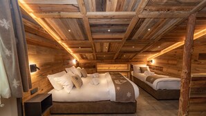 Una cabaña de madera con dos camas, cada una con cabecera y mesitas de noche.