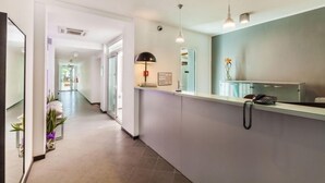 A reception area with a glass counter, a telephone, and a desk lamp. - Hibiscus Hotel Residence (Siniscola)
