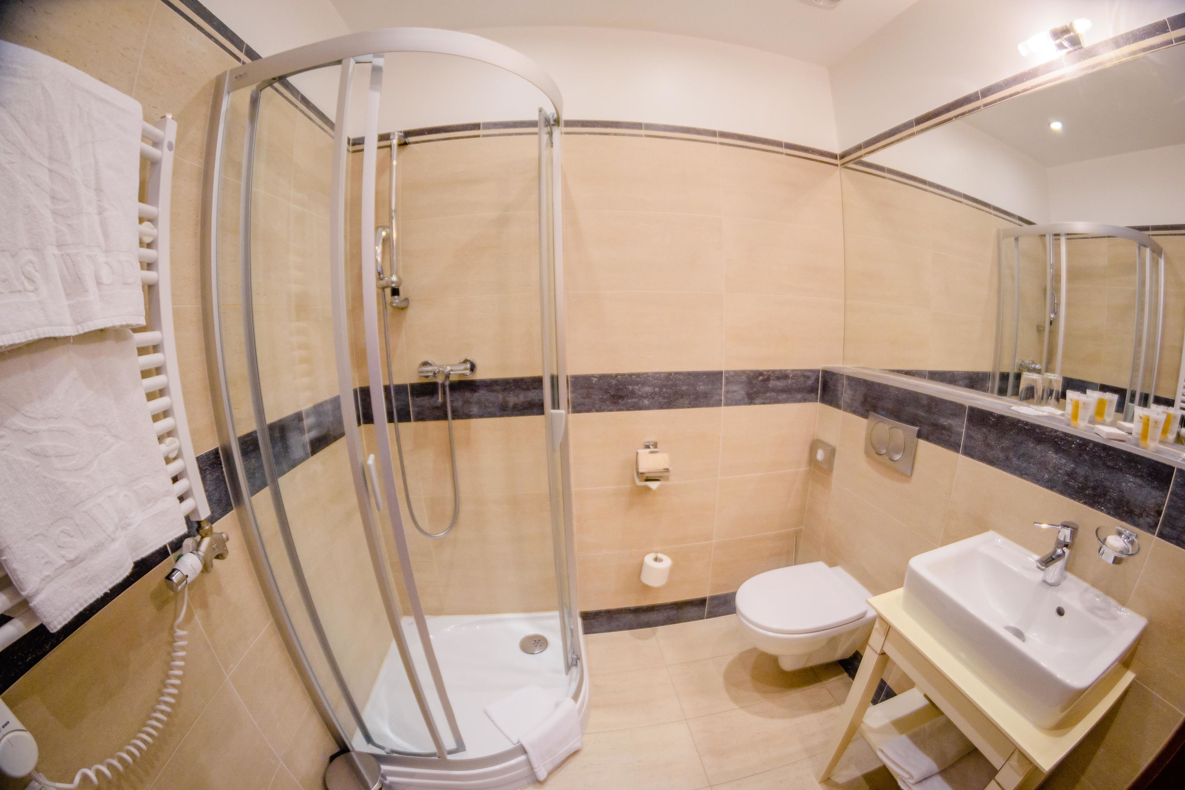 Un baño moderno con ducha acristalada, inodoro y lavamanos.