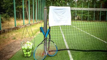 En tennisbane med et net, et håndklæde og tennisraketter.