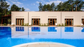 Un edificio moderno con piscina, ventanas amplias y cielo despejado.