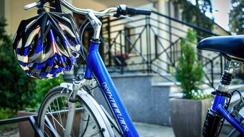 Ein Fahrrad mit Helm, befestigt am Lenker, steht in der Nähe einer Treppe mit Geländer.