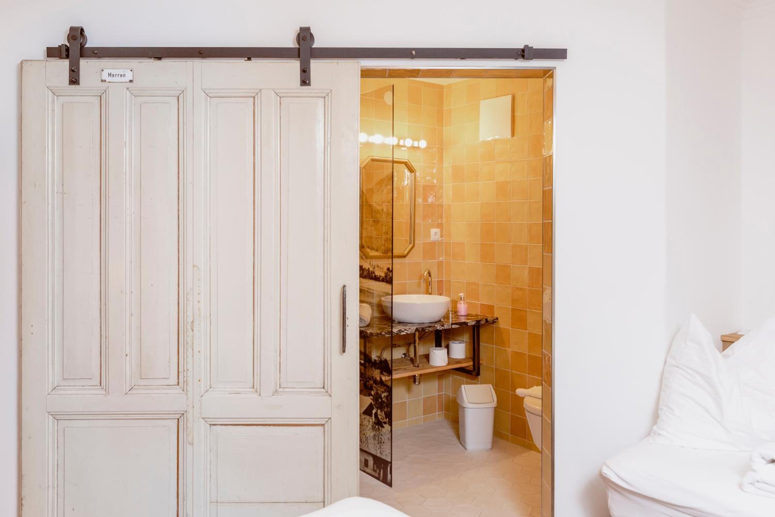 A bathroom with a white toilet, a sink, and a mirror.