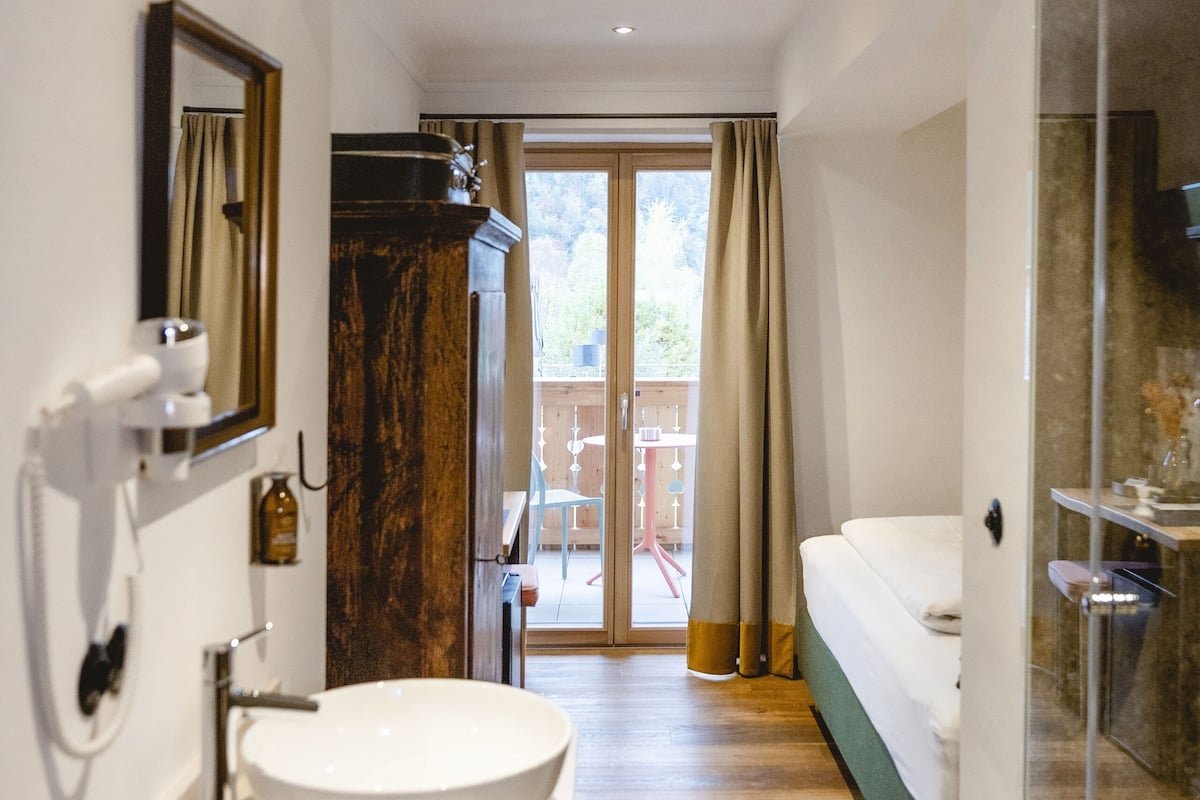 Une salle de bain moderne avec un grand lavabo, un miroir et une douche à l’italienne.