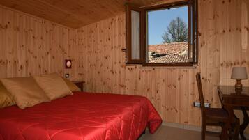 Ein Zimmer mit Holzwänden, einem Bett, einem Fenster und einem Stuhl.