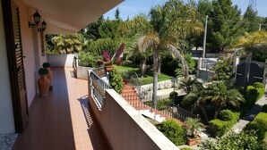 A balcony with a view of a landscaped garden, including various plants and a staircase leading to a lower level. - Villa Ottavia (Noto)