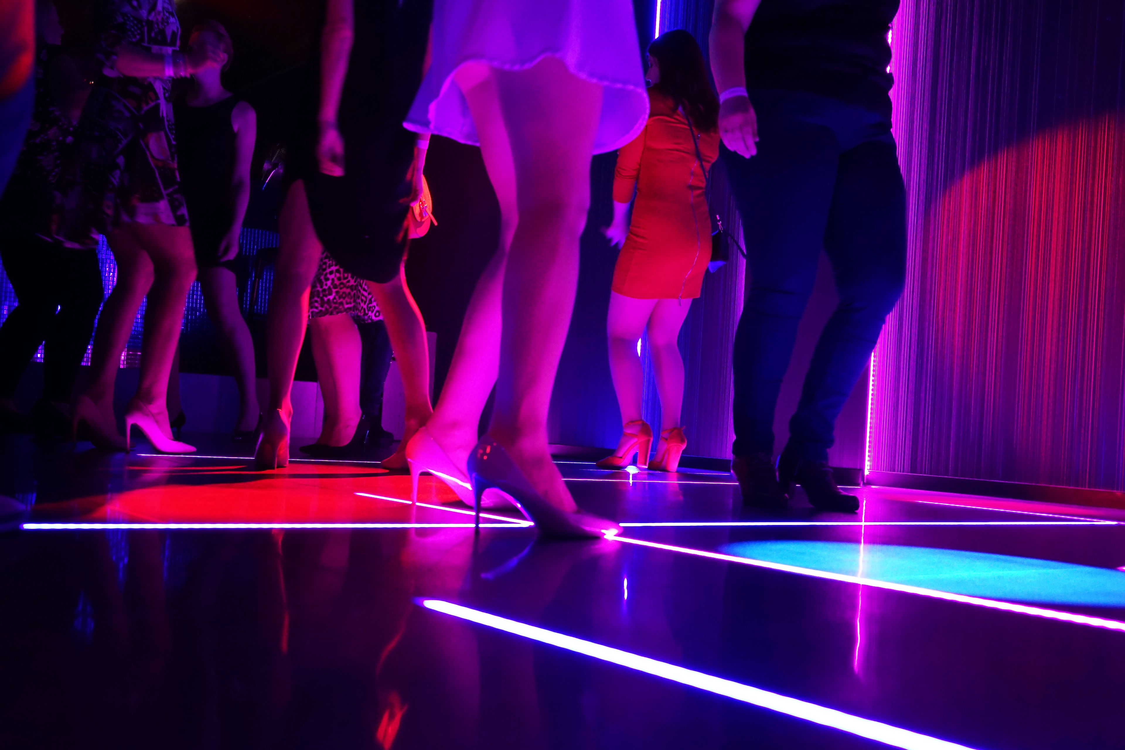 A dance floor with reflective surfaces and neon lights.