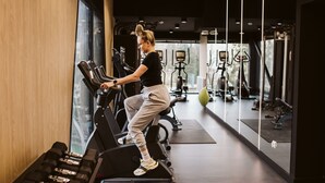 Een sportschool met trainingsapparatuur, waaronder loopbanden en gewichten.