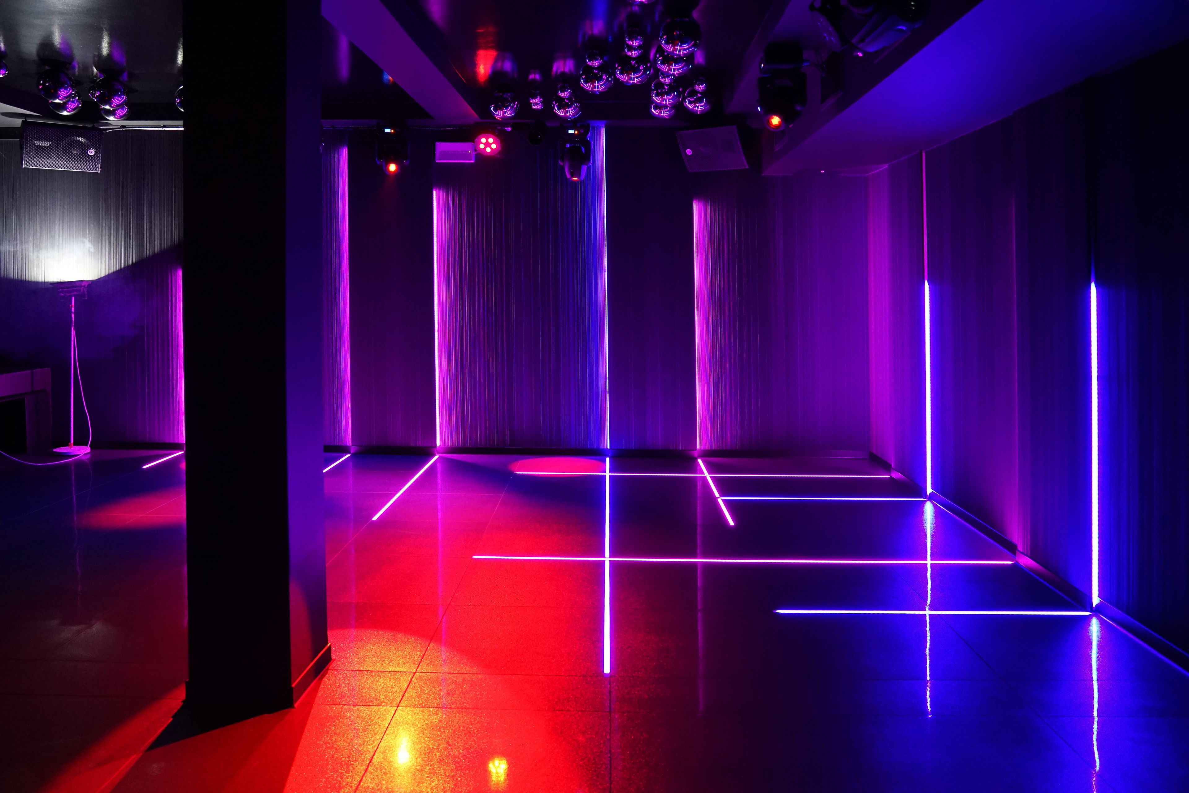 Une pièce dotée d’un sol réfléchissant et de bandes lumineuses verticales.