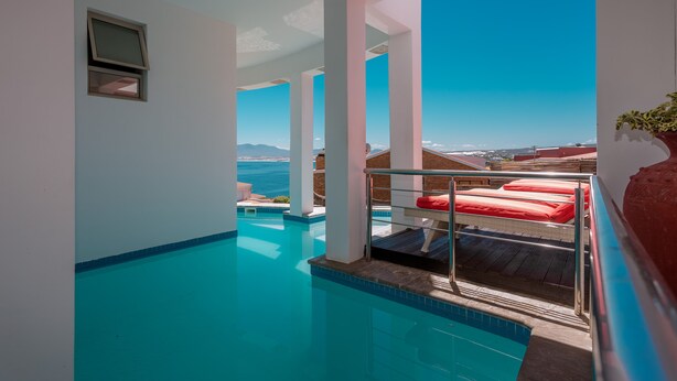 Una piscina infinita moderna con vistas despejadas al océano y montañas.