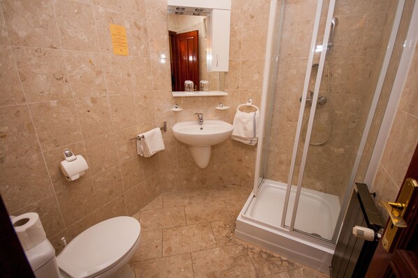A bathroom with a toilet, sink, and shower. - Korona Pension Restaurant (Hévíz)