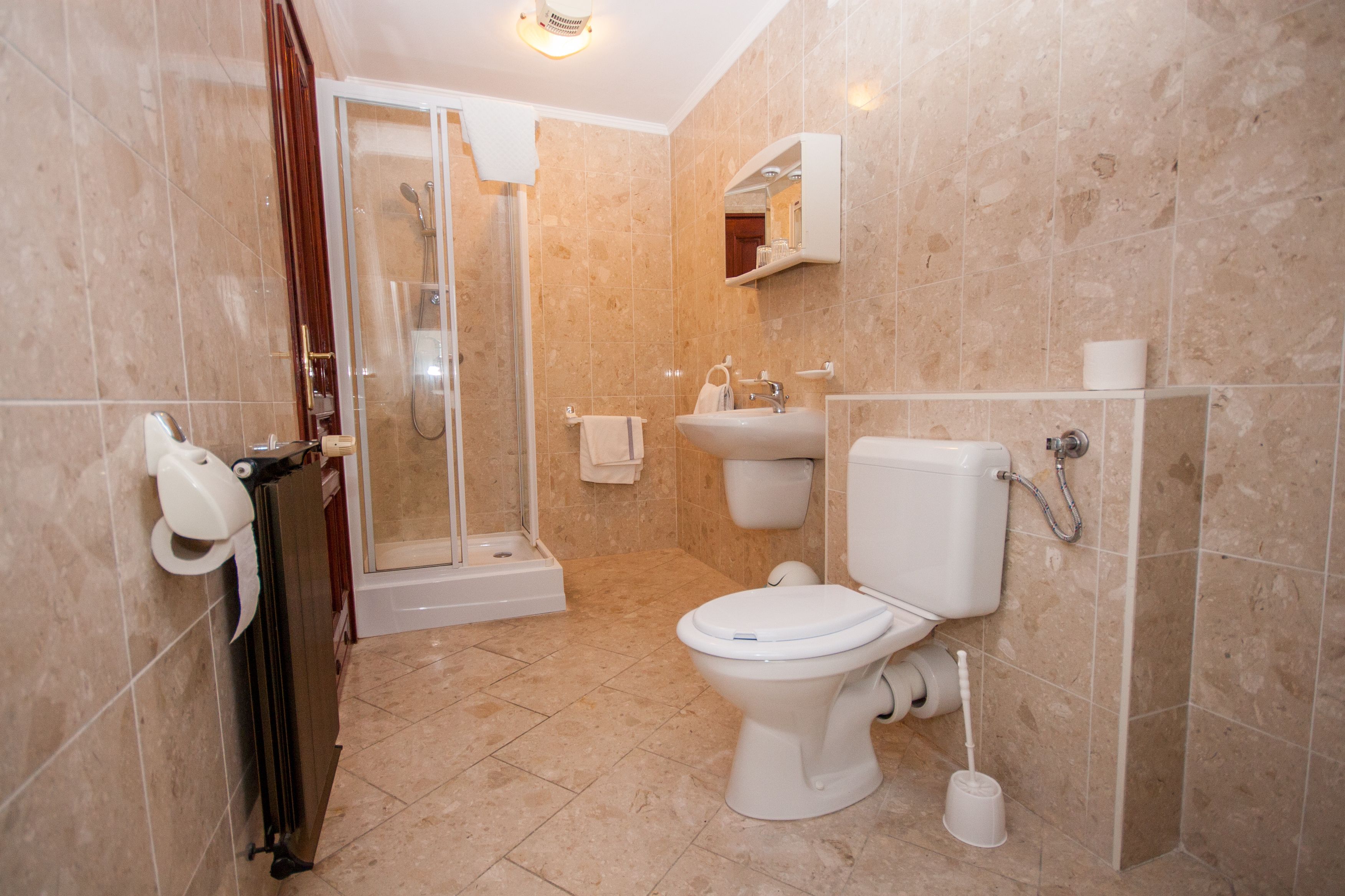 A bathroom with a toilet, sink, and shower.