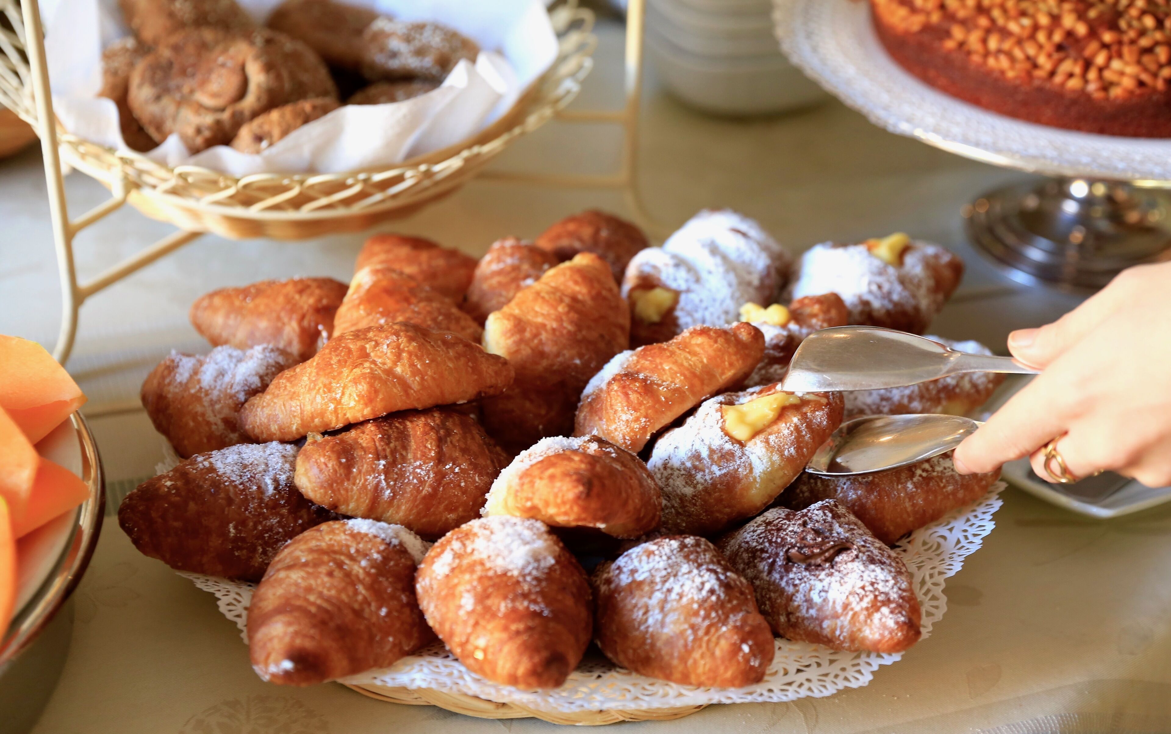 Variedad de pasteles, incluyendo croissants y otras delicias horneadas, sobre una mesa.