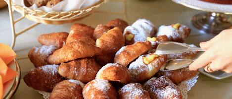 Variedad de pasteles, incluyendo croissants y otras delicias horneadas, sobre una mesa.